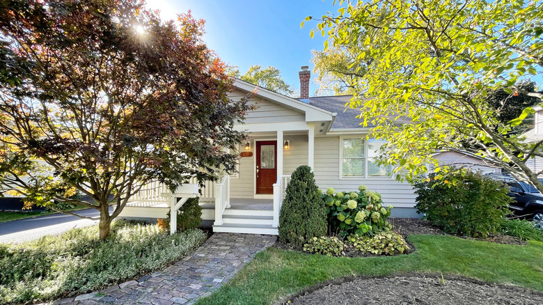 small white cottage with trees