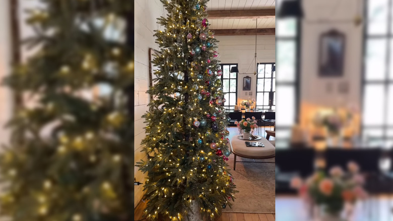 Joanna Gaines's Christmas tree in living area, half-covered with ornaments