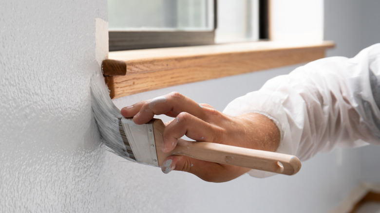 painting with paintbrush around trim