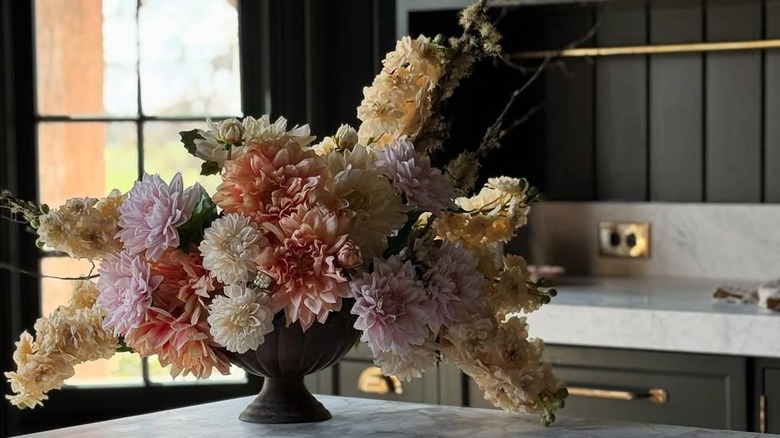 A bouquet of pastel flowers in a vintage vase.