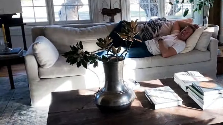 Chip Gaines on the couch in a farmhouse living room.
