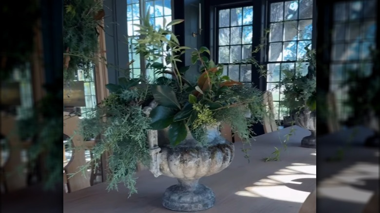Joanna Gaines cutting branches and creating an arrangement.
