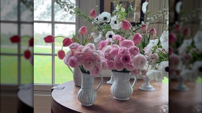 Several vases filled with pink and white flowers.