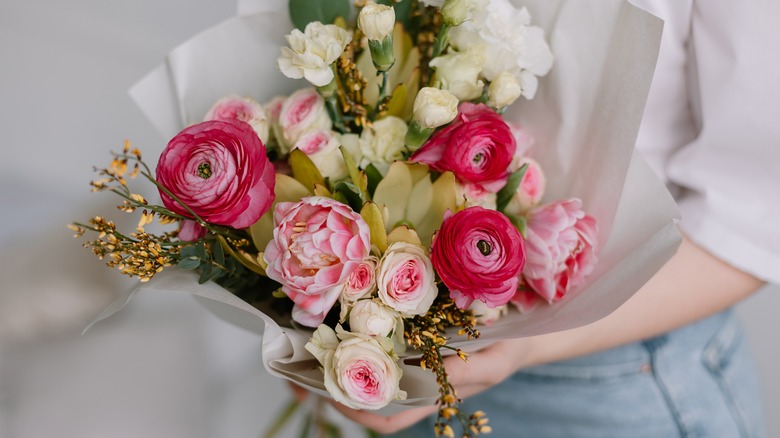 Woman holding flower arrangement