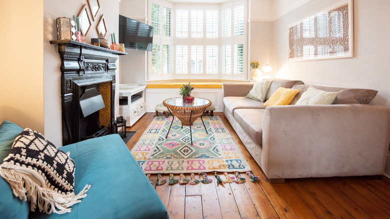 Interior view of boho-style room with colorful rug on wood floors