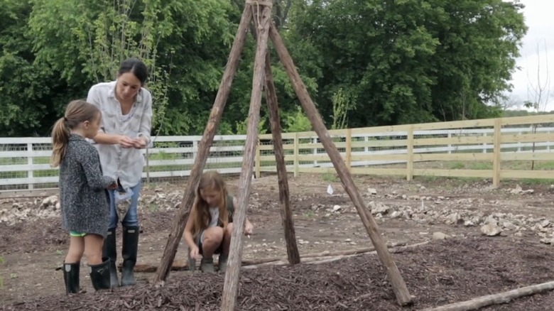 Joanna Gaines with her children in the garden, next to the teepee trellis