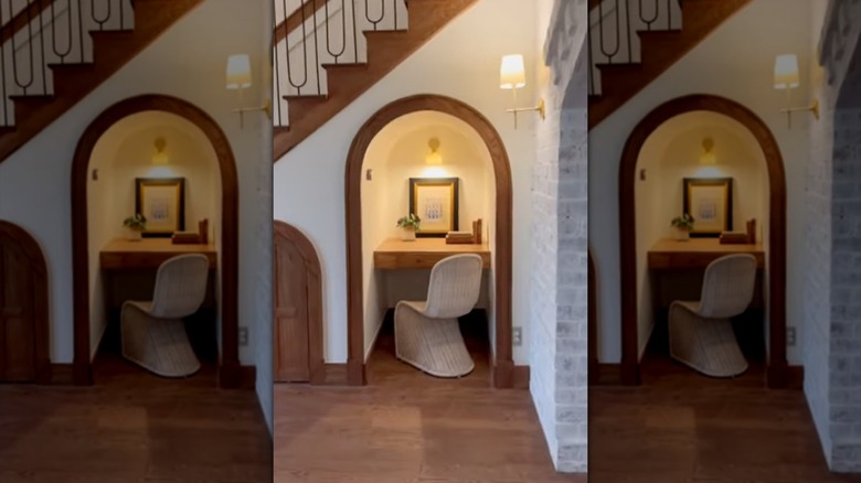 An office nook with a small desk under the stairs