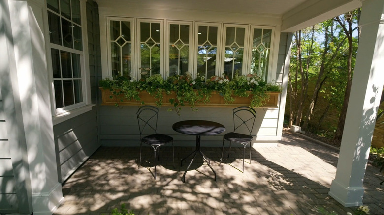 An outdoor dining set next to a window.