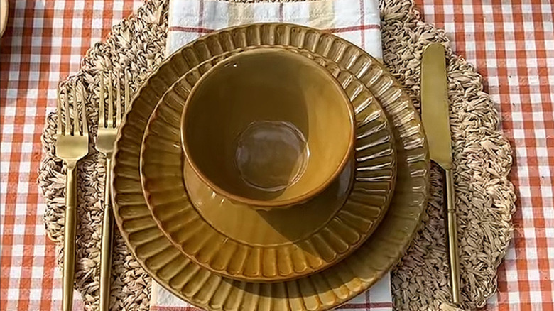 Dinnerplates on a plaid tablecloth.