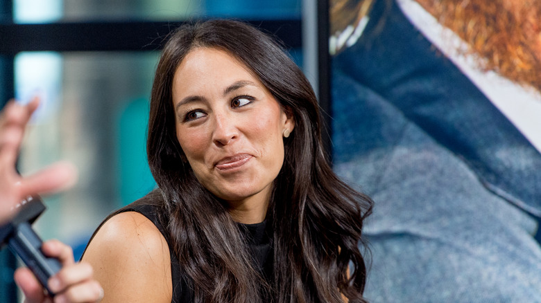 Joanna Gaines looks to the side during an interview on stage