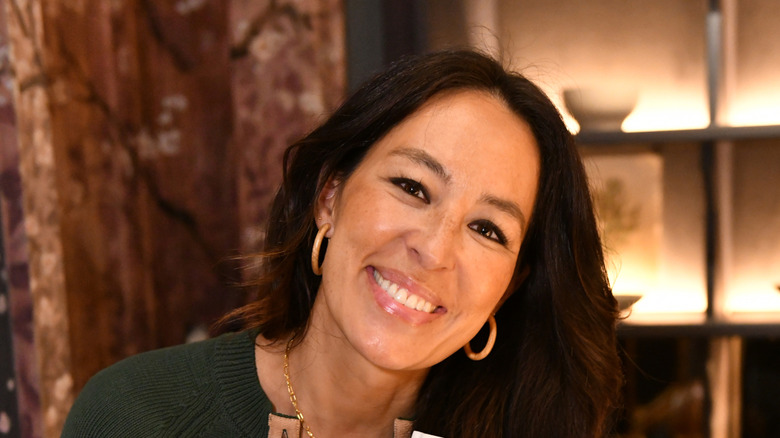 Joanna Gaines smiling in a dimly lit room