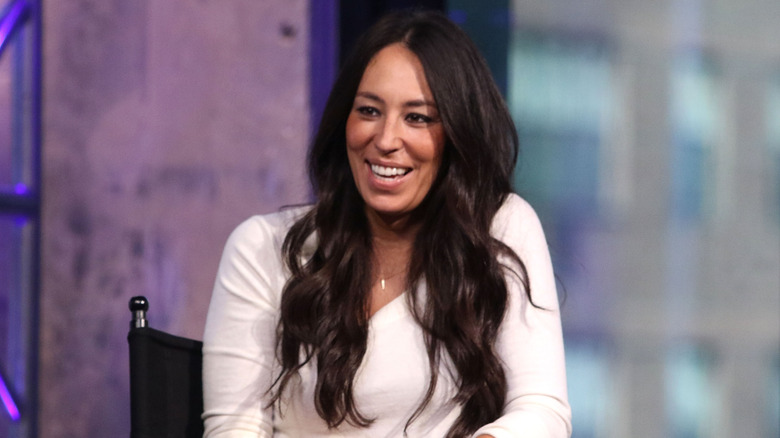 Joanna Gaines wearing a while, long-sleeved shirt