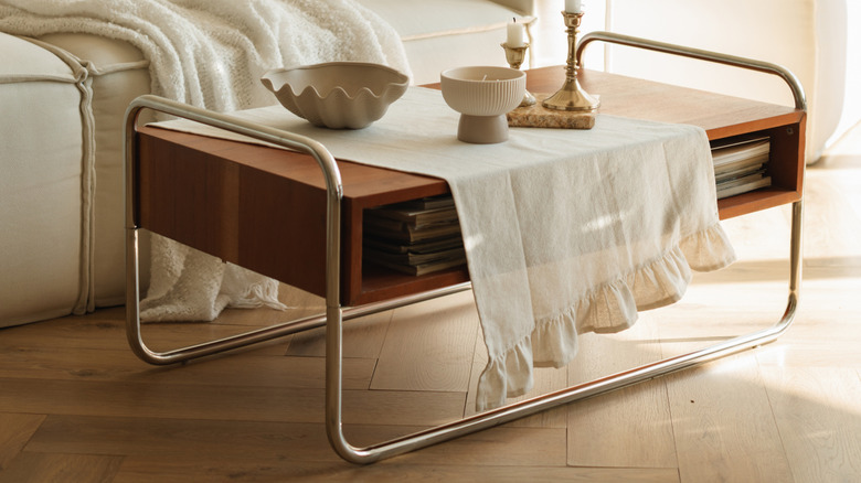 Couch with lightweight throw pillow and an end table with a cloth over it