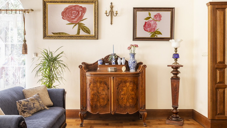 Vintage cabinet in living room flanked by flower painting