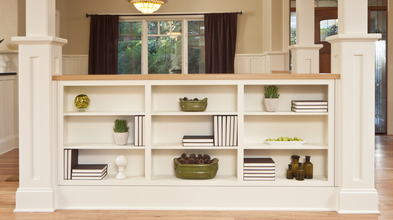 A neat built-in bookcase features books, plants, and ornaments