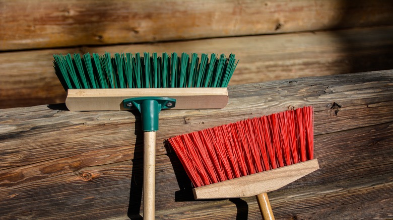 Two brooms on wood