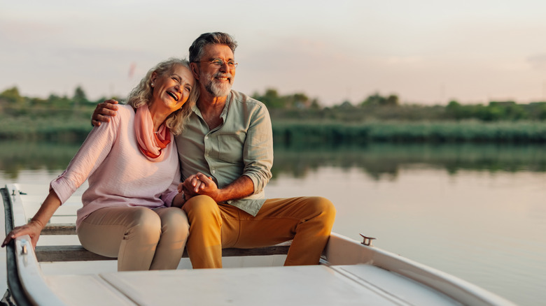 Couple sitting in a rowboat on a placid pond.