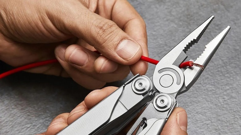 Person clipping wire with a multi-tool