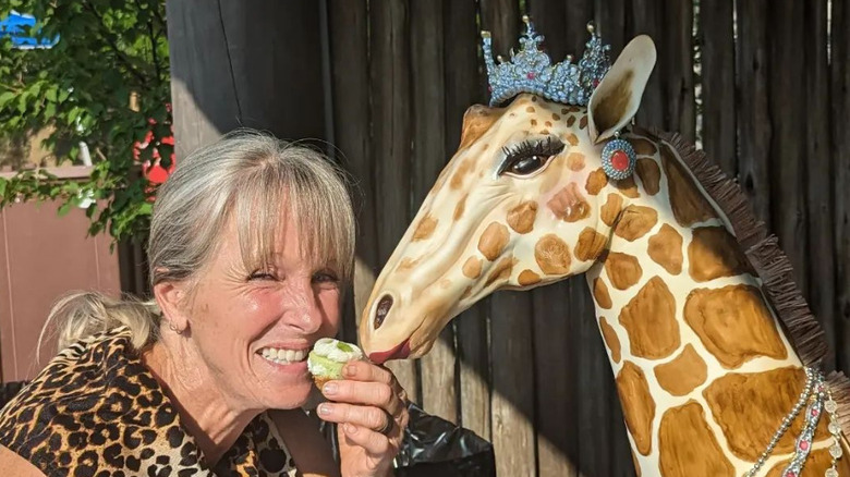 Karen E. Laine enjoying a cake with a royal giraffe