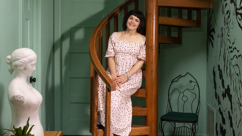 Katie Saro posing on wooden spiral staircase