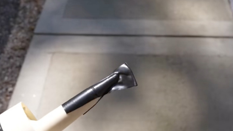 End of a caulk tube covered in tape