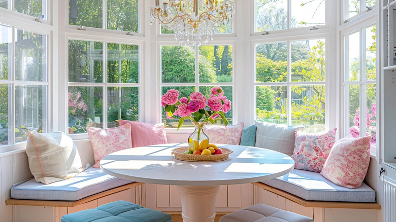 bay window breakfast nook with blue upholstery and floral pillows
