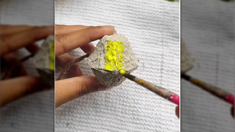 Person painting egg carton cups to make a craft bee