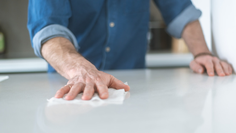 man wiping counter