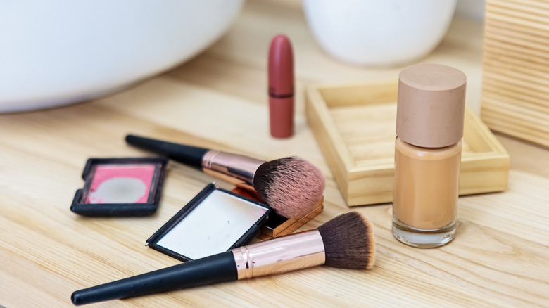makeup scattered on a bathroom counter