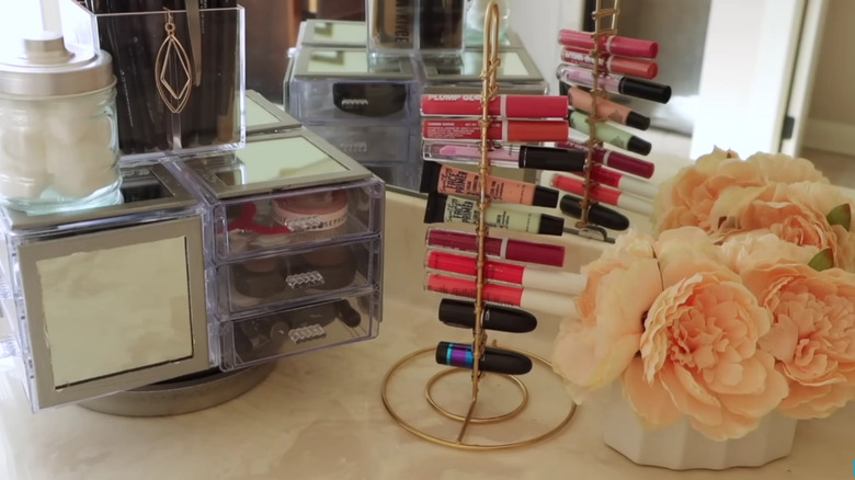 A repurposed paper towel holder used as a lipgloss stand.