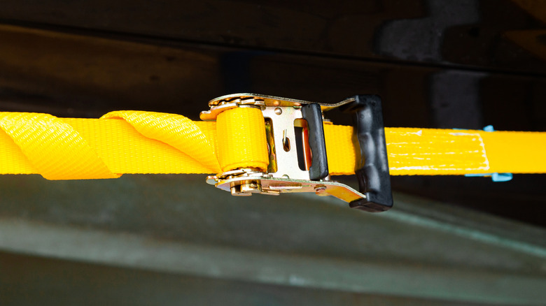 Yellow strap with ratchet device attached.