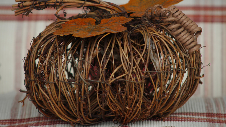 A close-up image of a grapevine pumpkin with decorative leaves
