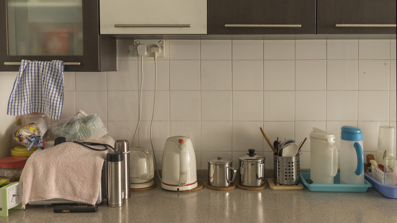 Kitchen countertop lined with dishware and appliances.