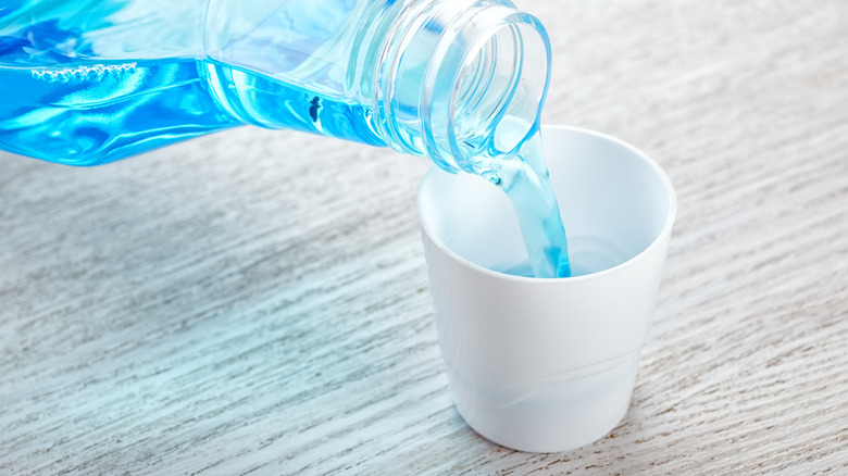 Pouring mouthwash into a cup