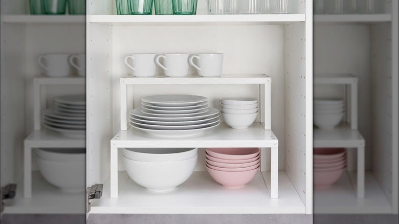 VARIERA shelf inserts in a cabinet with bowls, plates, mugs, and glasses