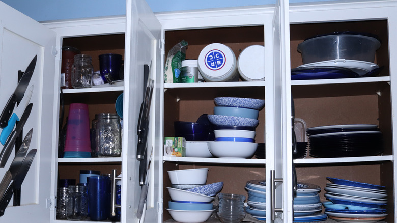 Cluttered and messily packed kitchen cabinet