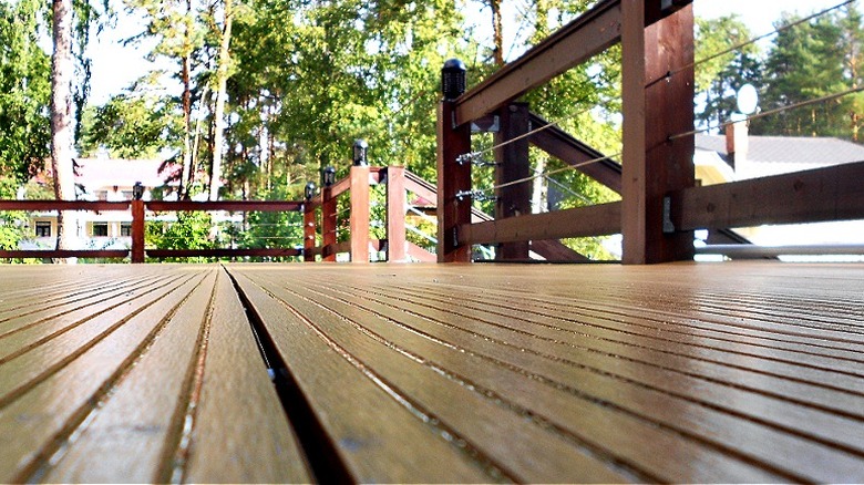 Ground-level view of a deck with cable railing and an opening to the steps on the right