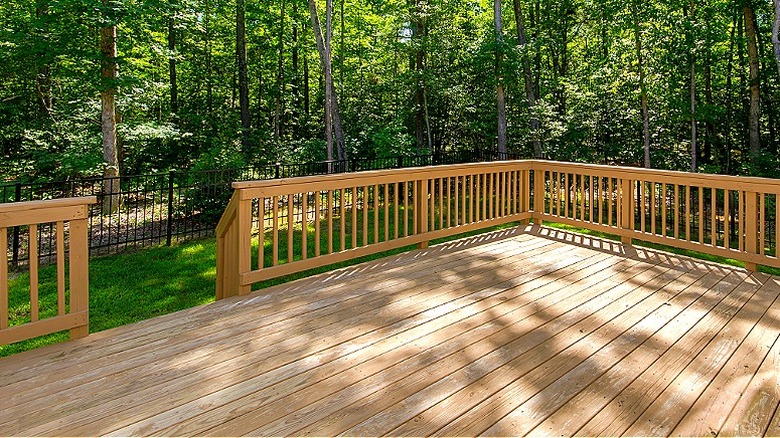 Deck with wood railing and an opening to the surrounding yard