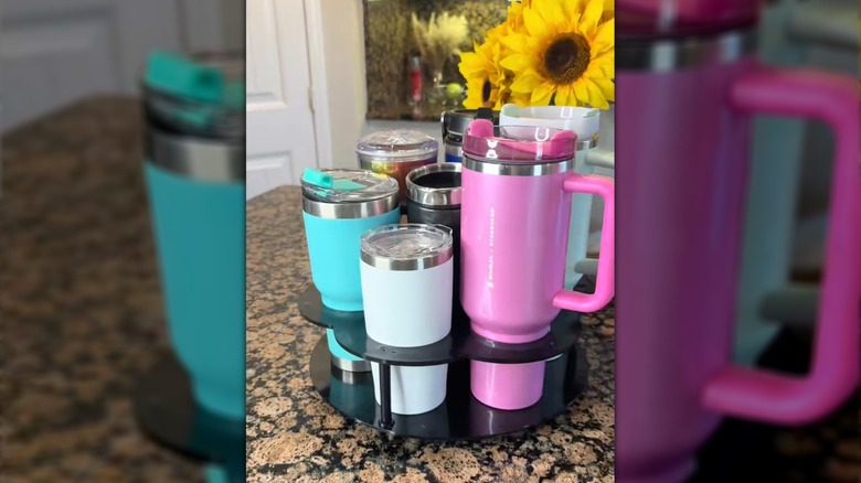 A Five Below tumbler spinner storage holder contains seven tumblers on a kitchen counter