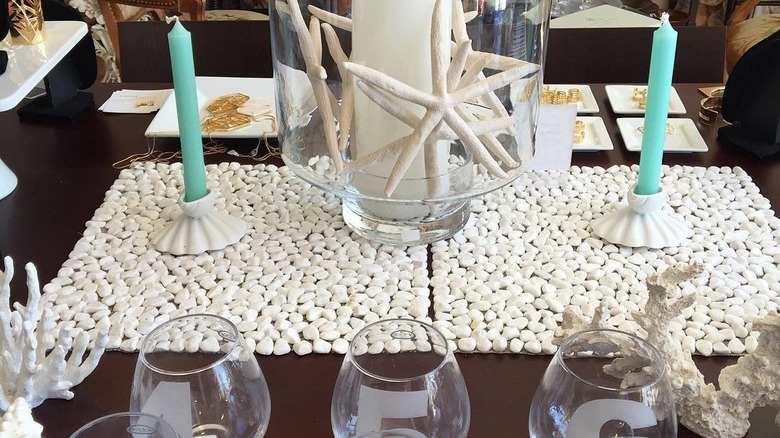 Pebble stone placemats with seashell and coastal decor and blue candles