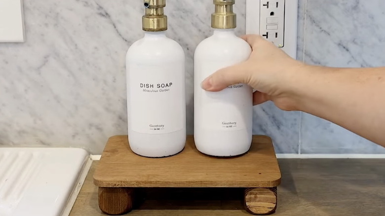 A Dollar Tree DIY miniature wood shelf with two bottles on top
