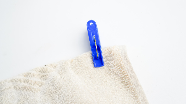 Close up of white towel hung up with blue clip