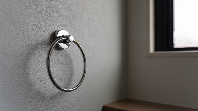Close up photo of silver towel ring on a wall