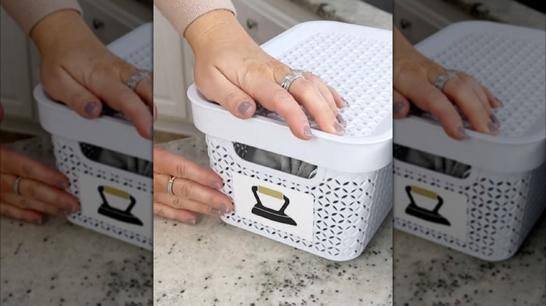 Woman placing label on Dollar Tree bin to organize laundry room