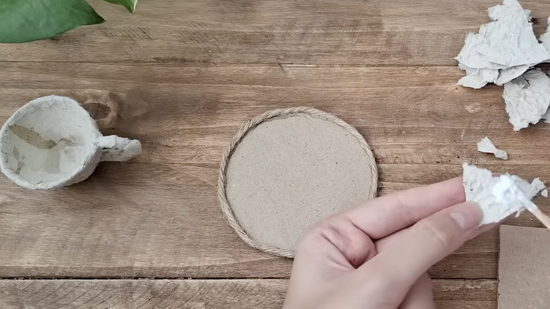 Cardboard egg carton teacup and saucer being made by hand