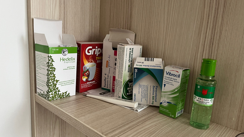 Various OTC medications on a shelf in a home.