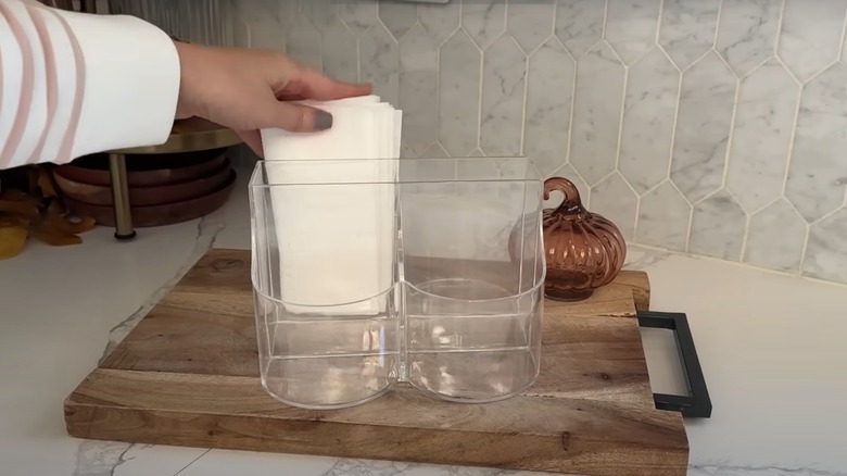 Woman placing napkins into a Dollar Tree cultery holder