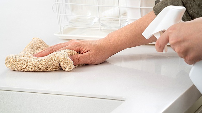 Spraying countertop with vinegar