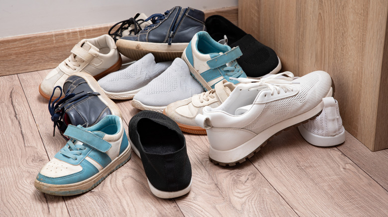 Shoes cluttered at the entryway of a home.