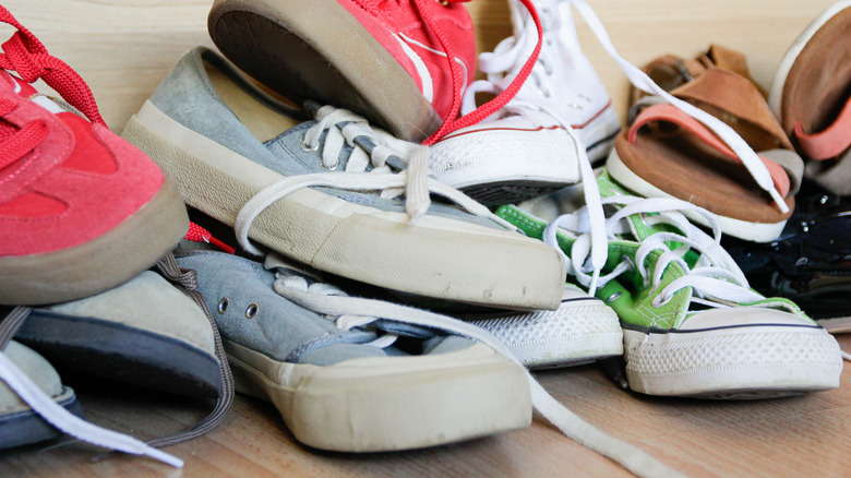 Lots of shoes piled messily on the floor
